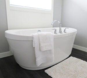 A luxurious ceramic, high-walled bathtub in a modern bathroom.