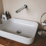 Wall mounted touchless faucet above a modern bathroom sink
