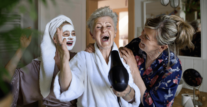 Senior women laughing together during home spa and hair drying session